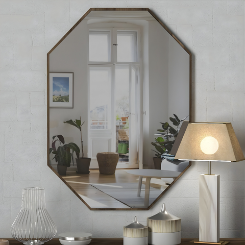Hexagonal mirror on a wall with decorative items below